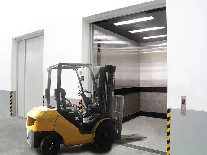 forklift carrying goods entering into goods elevator