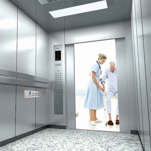 nurse helping patient into hospital elevator